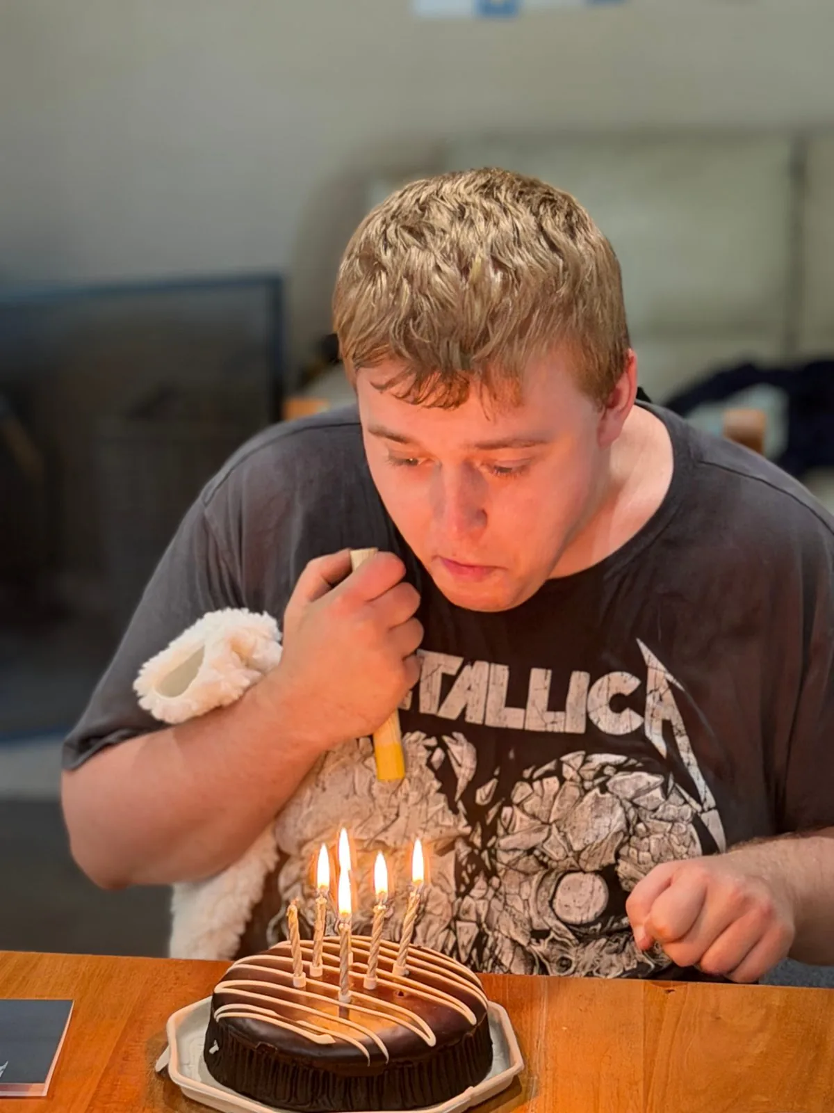Participant blowing out candles on a chocolate birthday cake