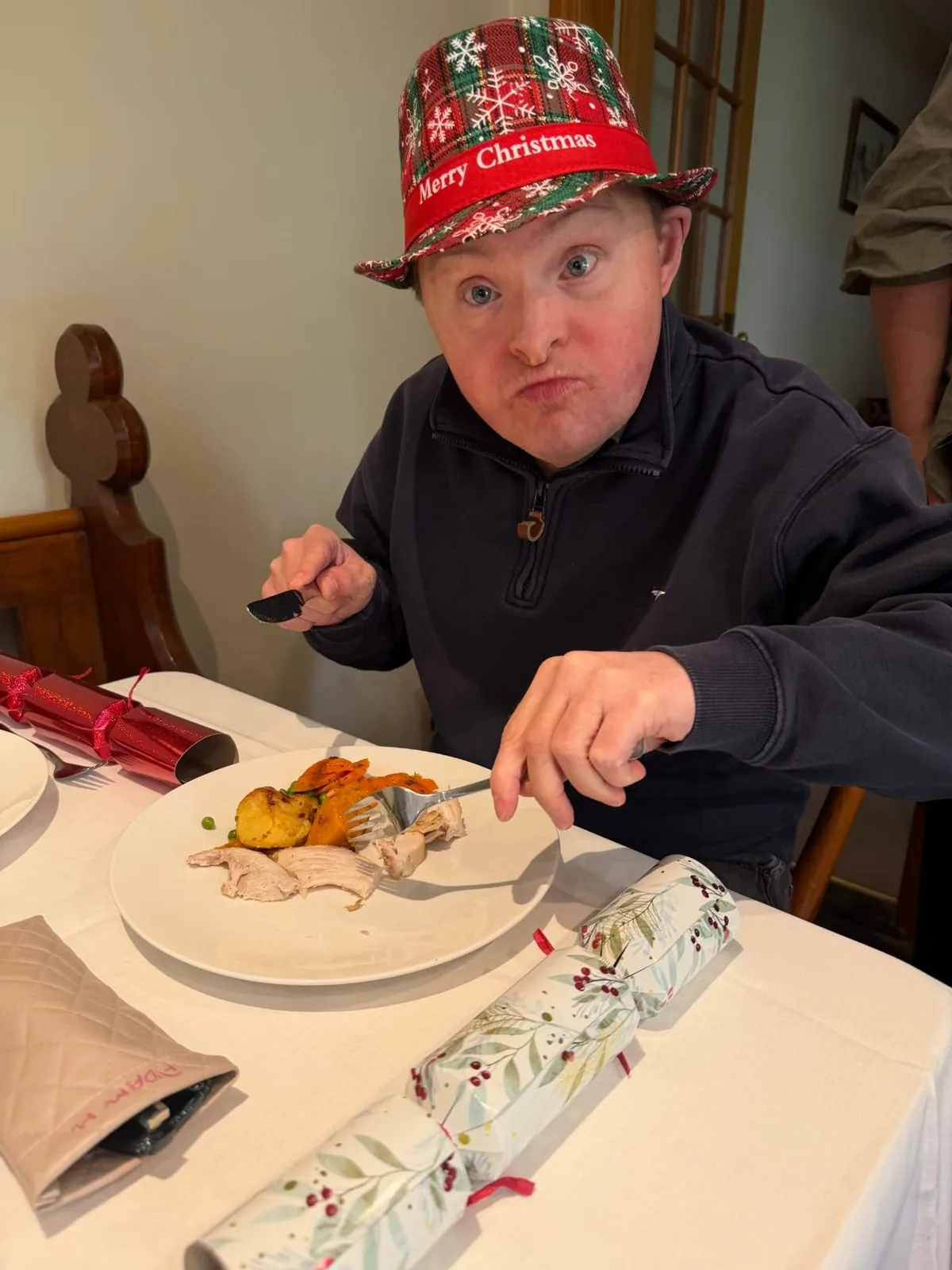 Participant in a Merry Christmas hat enjoying Christmas lunch at the table