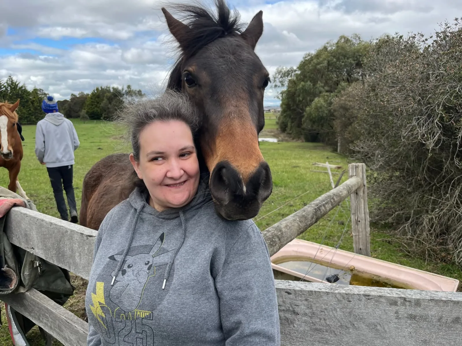 Participant sharing a cuddle with a horse over the fence