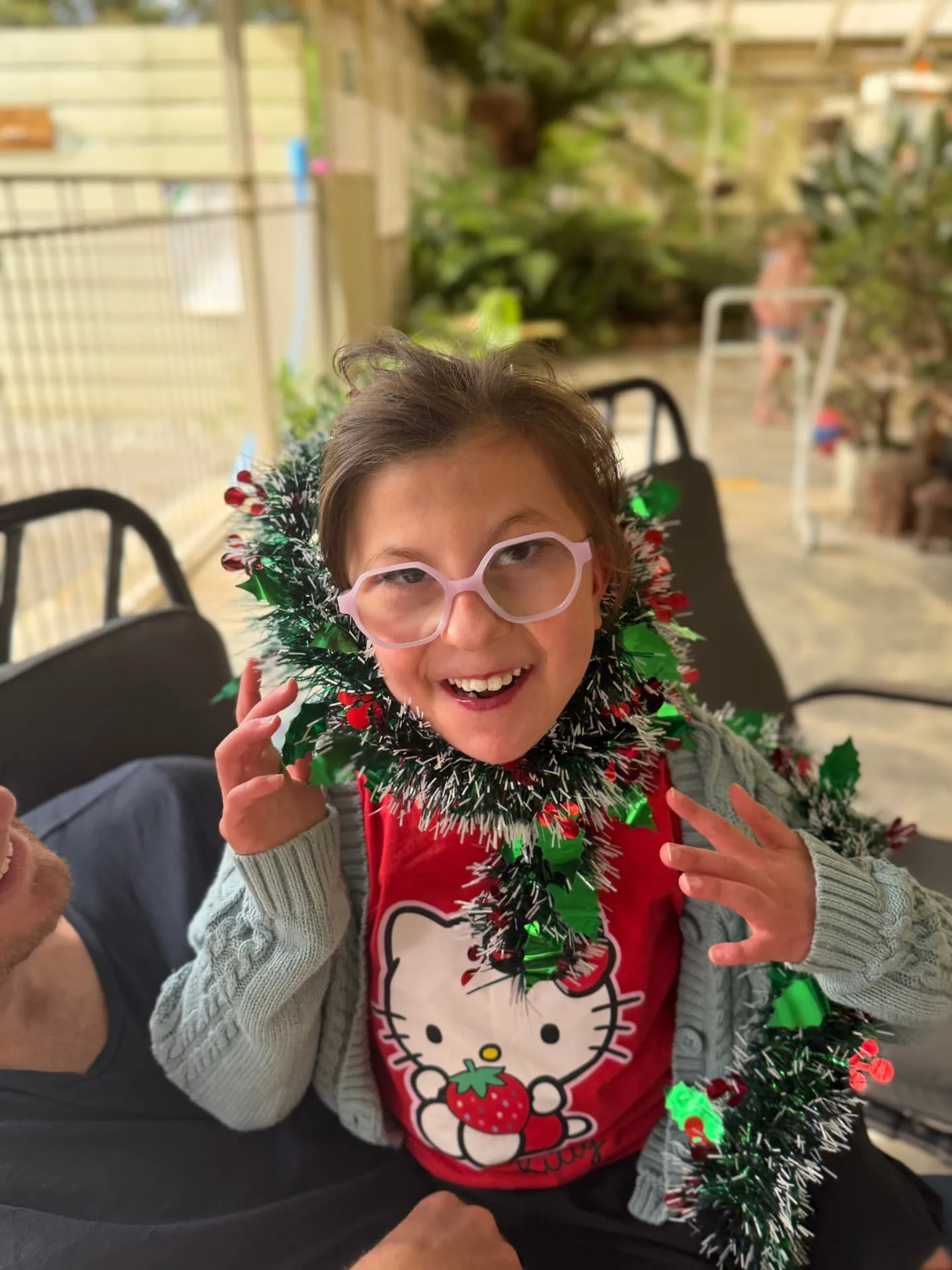 Participant grinning with festive tinsel around her shoulders