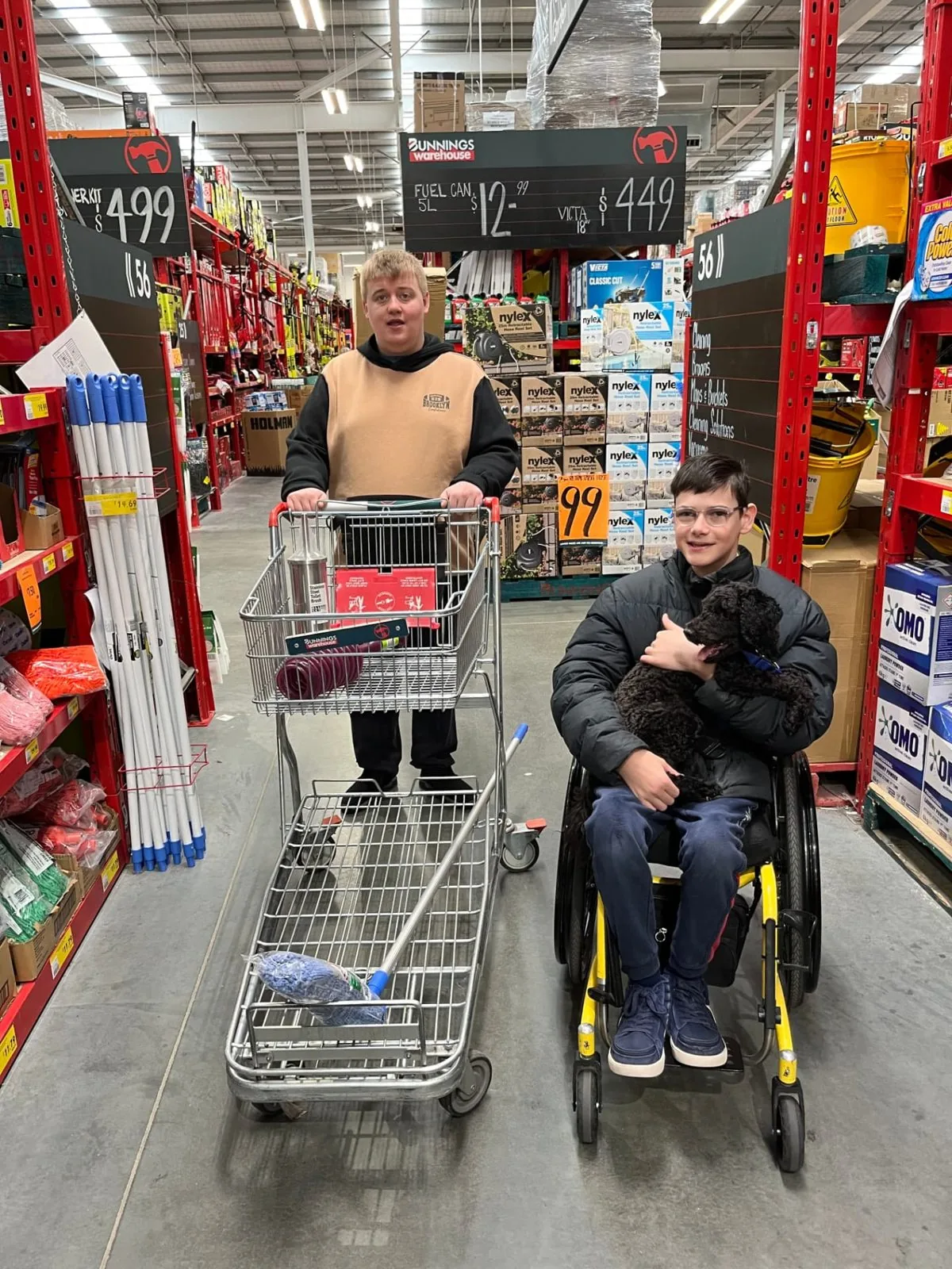 Two participants shopping together at Bunnings with a support dog